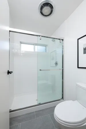 a bathroom with a toilet and a shower