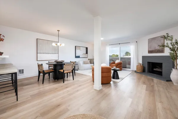 a living room with furniture dining table a fireplace and a refrigerator