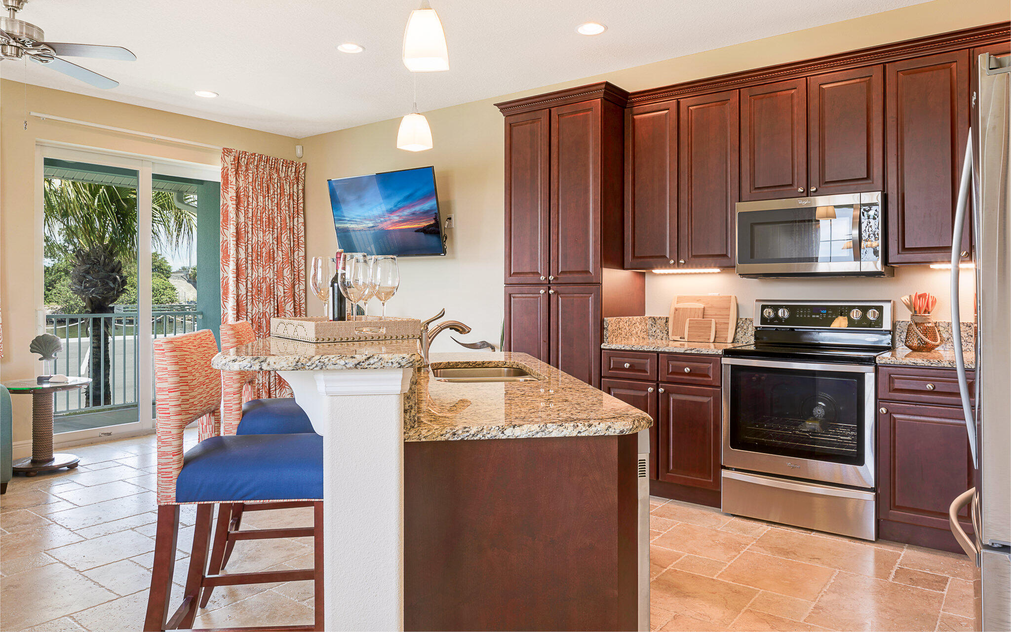 a kitchen with kitchen island granite countertop a stove top oven a sink dishwasher and cabinets with wooden floor