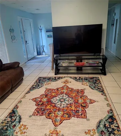 a living room with a flat screen tv and a rug