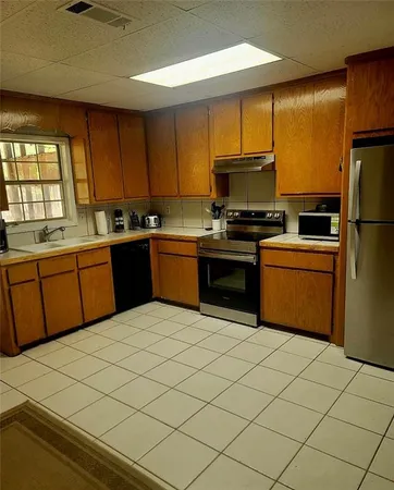 a kitchen with stainless steel appliances granite countertop a stove sink and cabinets