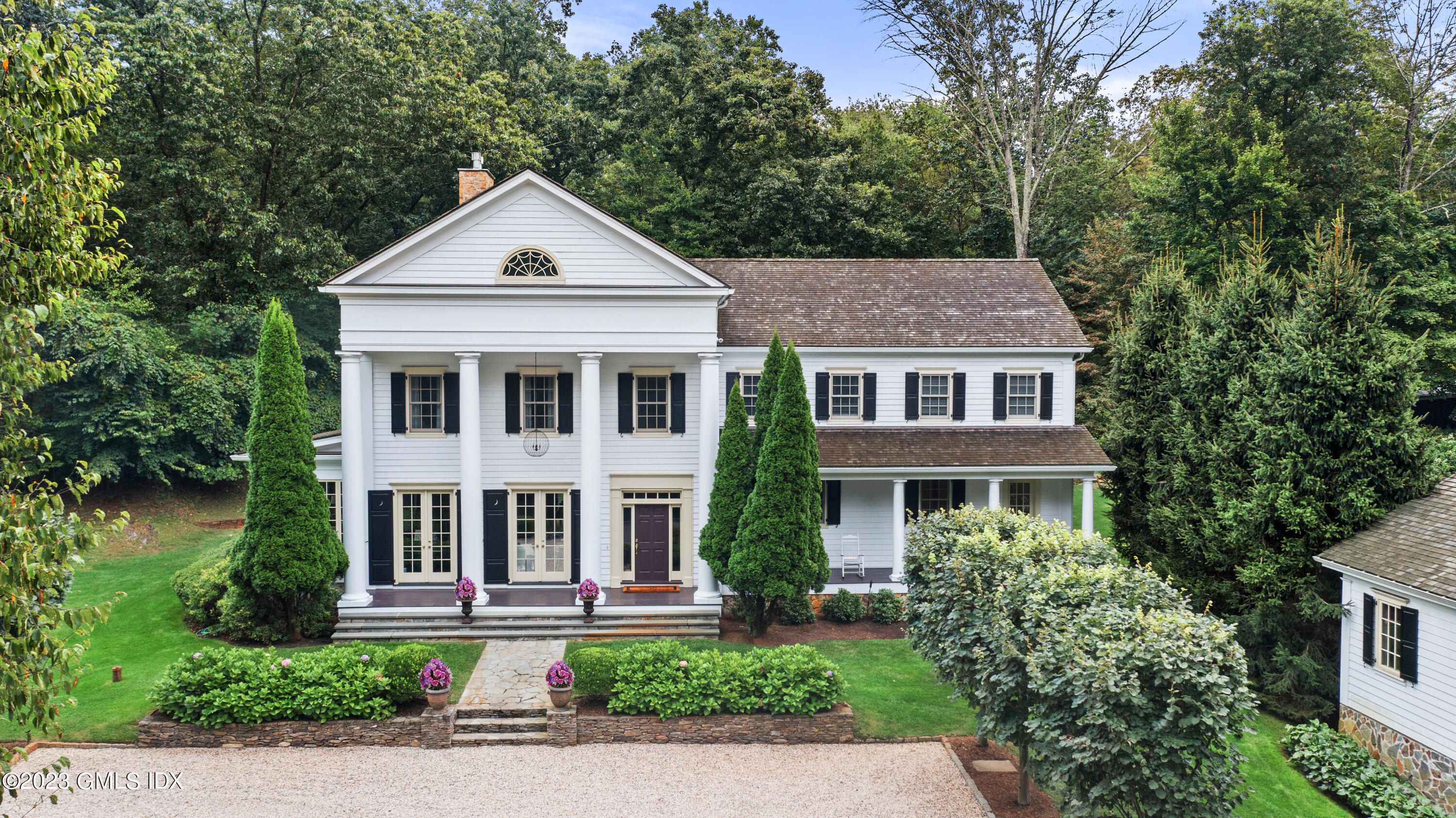 37 North Porchuck Road Greenwich, CT 06831 - Photo 1 of 63 a front view of a house with a yard and plants