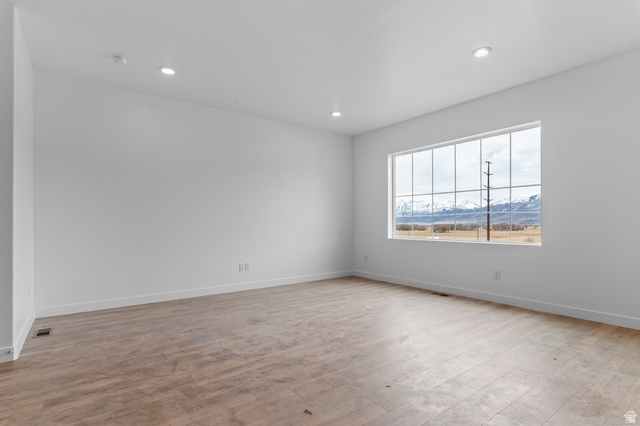 2829 South 710th West, Unit 17 Logan, UT 84321 - Photo 9 of 22 Spare room featuring light wood-style floors, a mountain view, and recessed lighting
