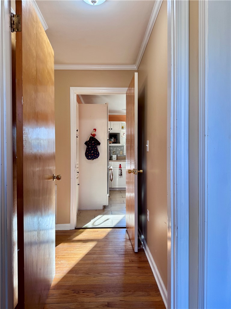 208 Pilgrim Circle Pickens, SC 29671 - Photo 3 of 29 This interior hallway features hardwood floors, leading to a well-appointed kitchen with white cabinetry.