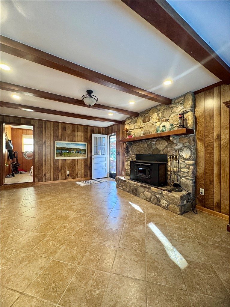 208 Pilgrim Circle Pickens, SC 29671 - Photo 7 of 29 This inviting living space features warm wood paneling, a stone fireplace, and exposed beam ceilings.