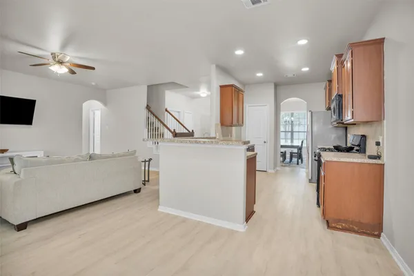 a large white kitchen with a large window a sink and stainless steel appliances