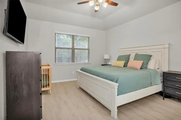 a bedroom with a bed and a flat tv screen on a dresser