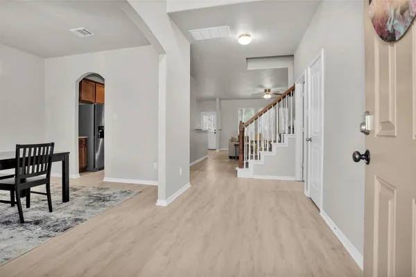 a view of a hallway with wooden floor and stairs