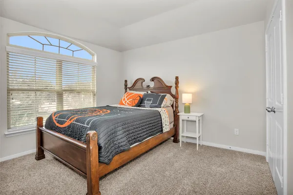 a bed sitting in a bedroom next to a window
