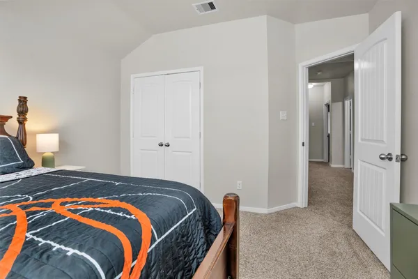 a bedroom with a bed and a lamp