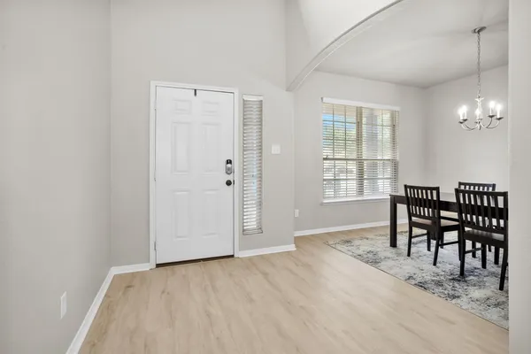 an empty room with windows and wooden floor