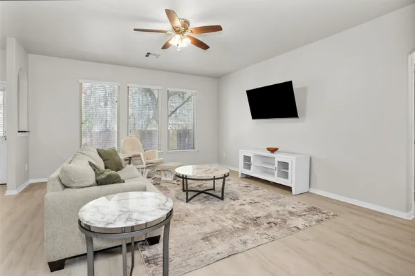 a living room with furniture a flat screen tv and a window