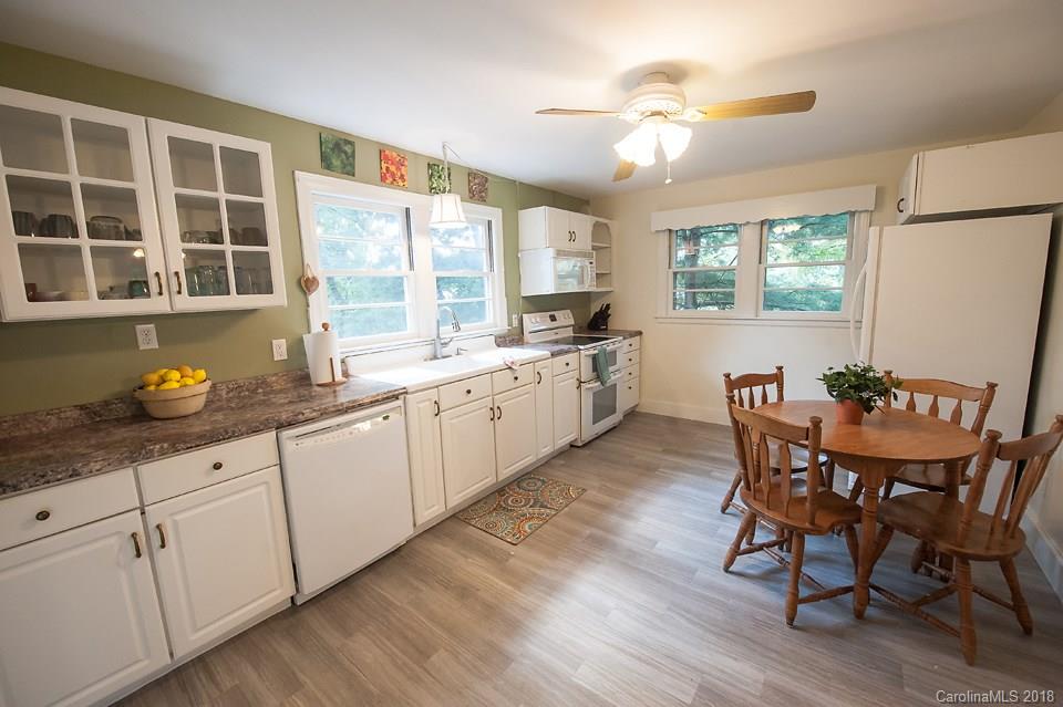 288 Deaverview Road, Unit B Asheville, NC 28806 - Photo 3 of 28 a kitchen with granite countertop a dining table chairs cabinets and stainless steel appliances