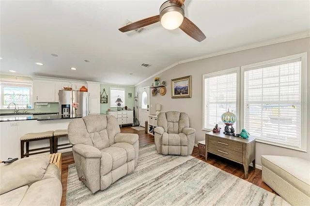 a living room with furniture kitchen view and a chandelier