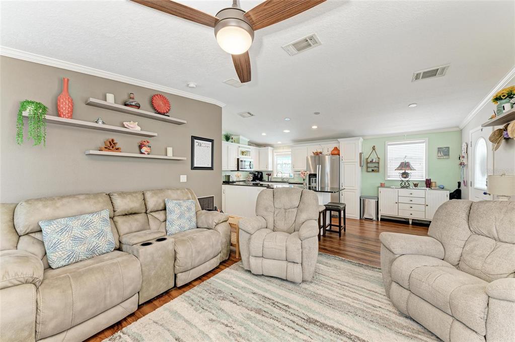 12507 Cortez Road West, Unit 35 Cortez, FL 34215 - Photo 12 of 36 a living room with furniture kitchen view and a chandelier