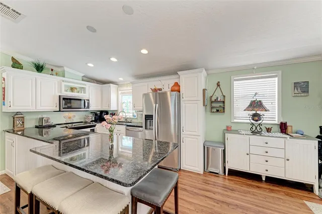 a kitchen with stainless steel appliances granite countertop a refrigerator stove microwave and sink