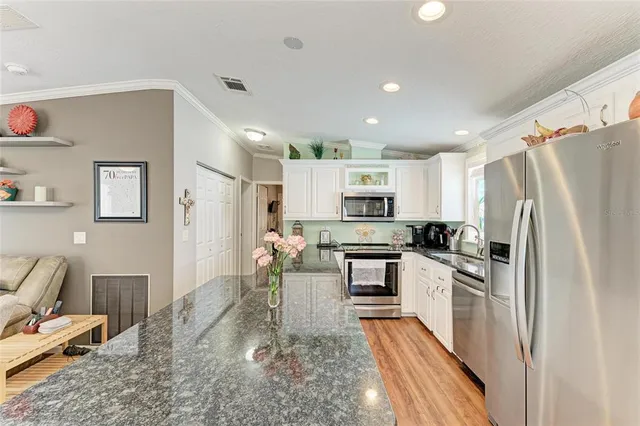 a kitchen with stainless steel appliances granite countertop a refrigerator a stove top oven a sink and dishwasher