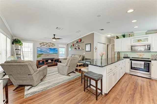 a living room with furniture a flat screen tv and a large window