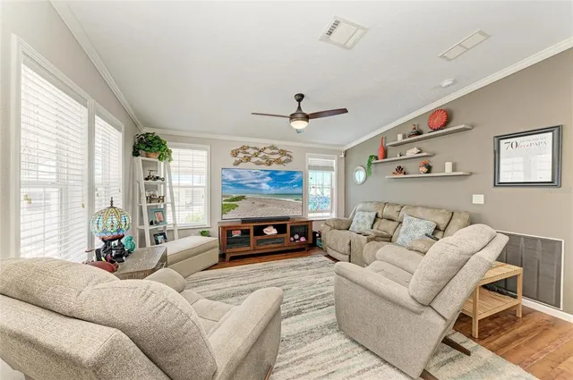 a living room with furniture a large window and a flat screen tv