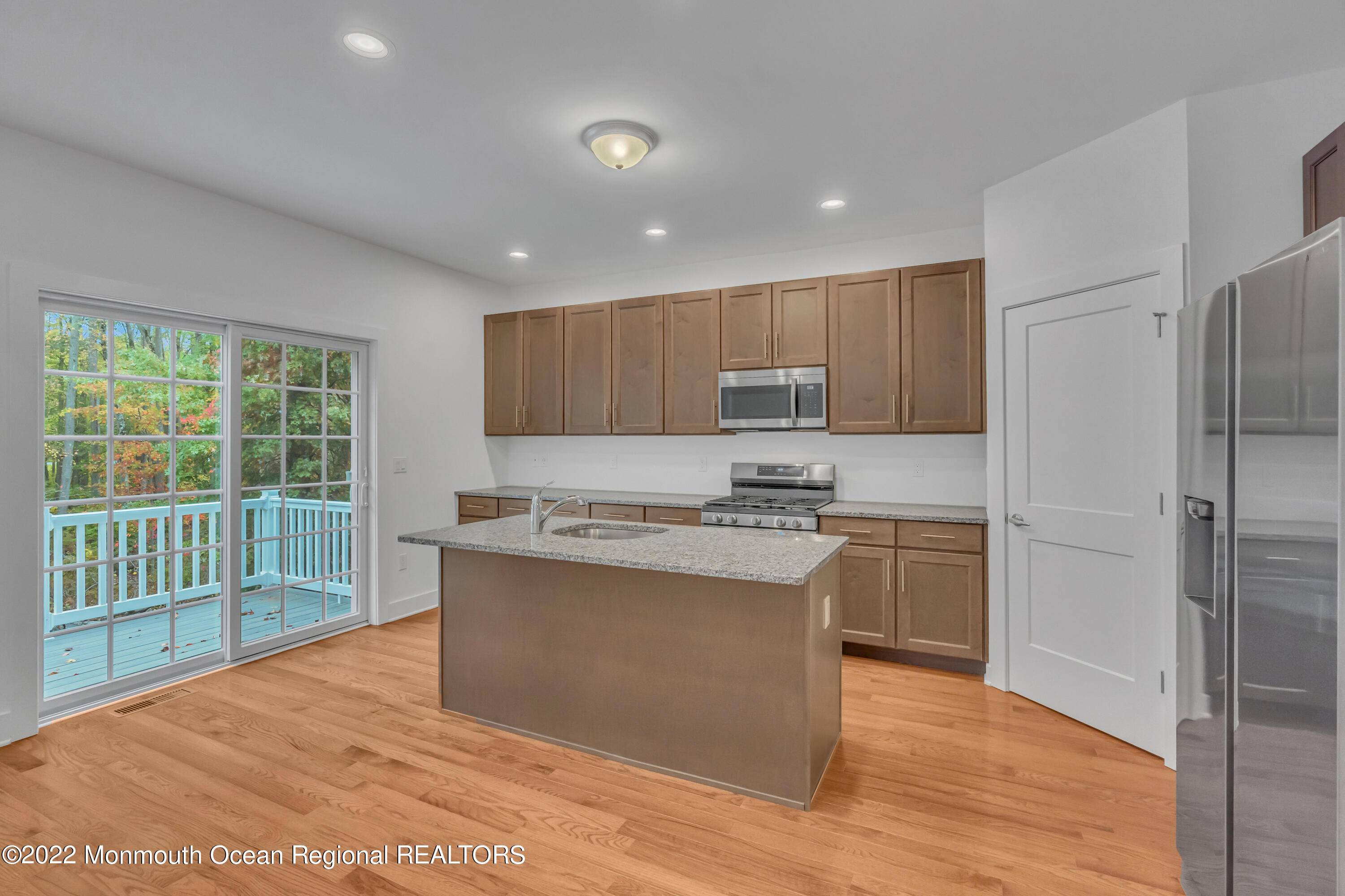 26 Kitchen Avenue Old Bridge, NJ 08857 - Photo 17 of 38 a kitchen with stainless steel appliances granite countertop a stove top oven a refrigerator a sink and dishwasher with wooden floor