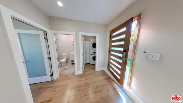 a view of a hallway with wooden shelves and a window