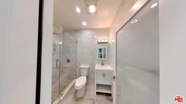 a bathroom with a toilet a sink and shower