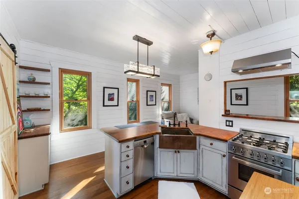 a kitchen with stainless steel appliances a stove a sink and a refrigerator
