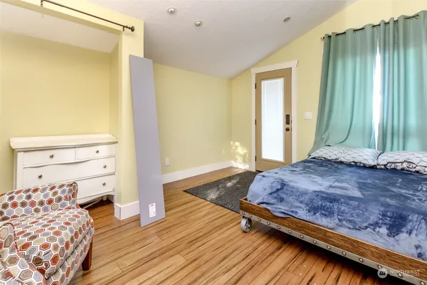 a bedroom with a bed and wooden floor