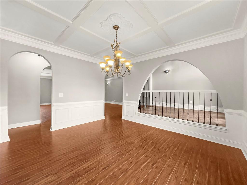 335 Canvasback Trail Locust Grove, GA 30248 - Photo 19 of 91 a view of an empty room with wooden floor and a chandelier