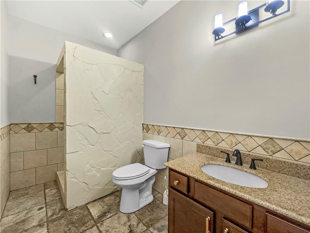 335 Canvasback Trail Locust Grove, GA 30248 - Photo 26 of 91 a bathroom with a granite countertop toilet sink and mirror