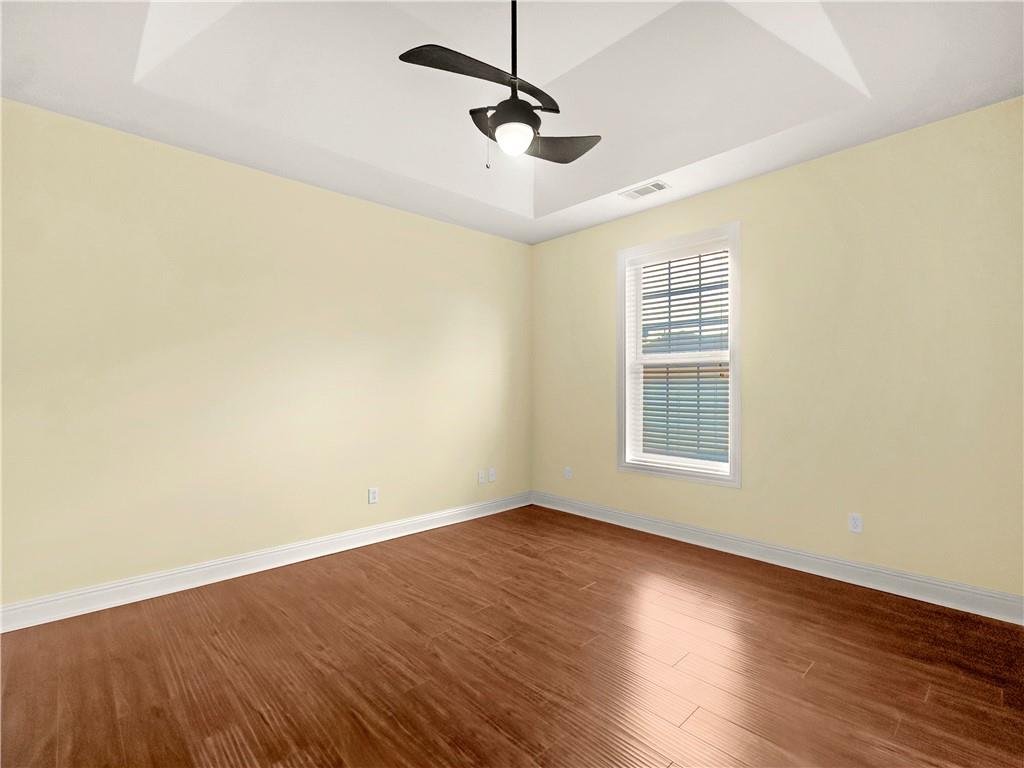335 Canvasback Trail Locust Grove, GA 30248 - Photo 31 of 91 an empty room with wooden floor ceiling fan and windows