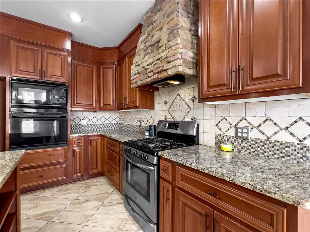 335 Canvasback Trail Locust Grove, GA 30248 - Photo 49 of 91 a kitchen with stainless steel appliances granite countertop a stove a sink and a microwave