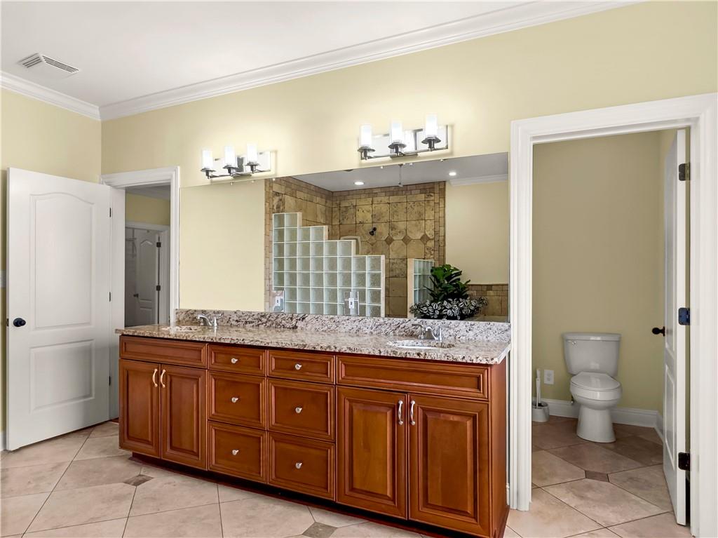 335 Canvasback Trail Locust Grove, GA 30248 - Photo 67 of 91 a spacious bathroom with a granite countertop sink and a mirror