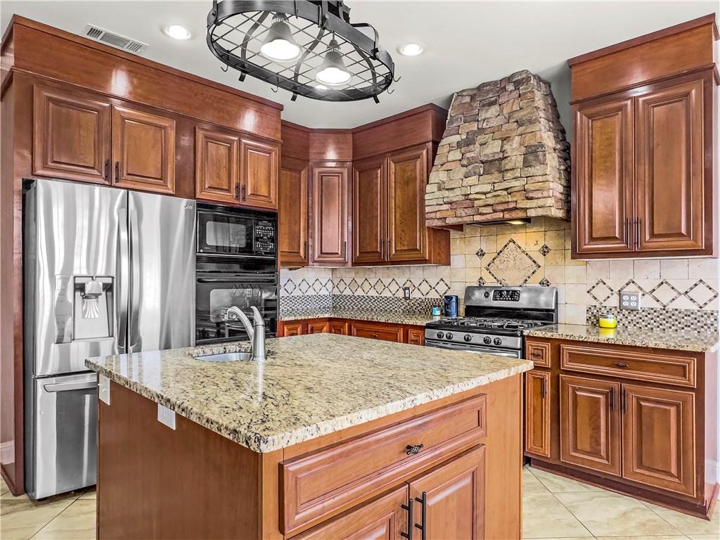 335 Canvasback Trail Locust Grove, GA 30248 - Photo 71 of 91 a kitchen with stainless steel appliances granite countertop a sink refrigerator stove and microwave