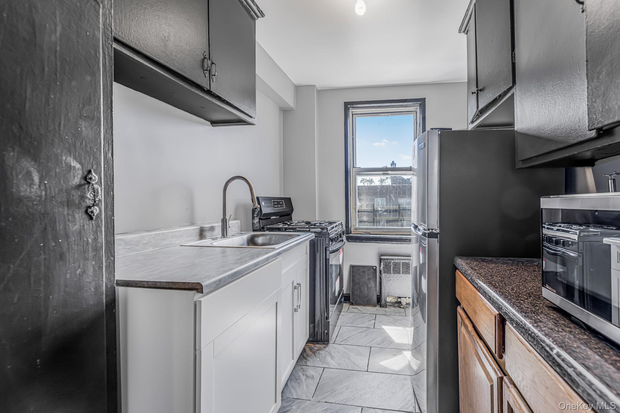 150 Ravine Avenue, Unit 3B Yonkers, NY 10701 - Photo 6 of 9 a kitchen with a sink refrigerator and cabinets