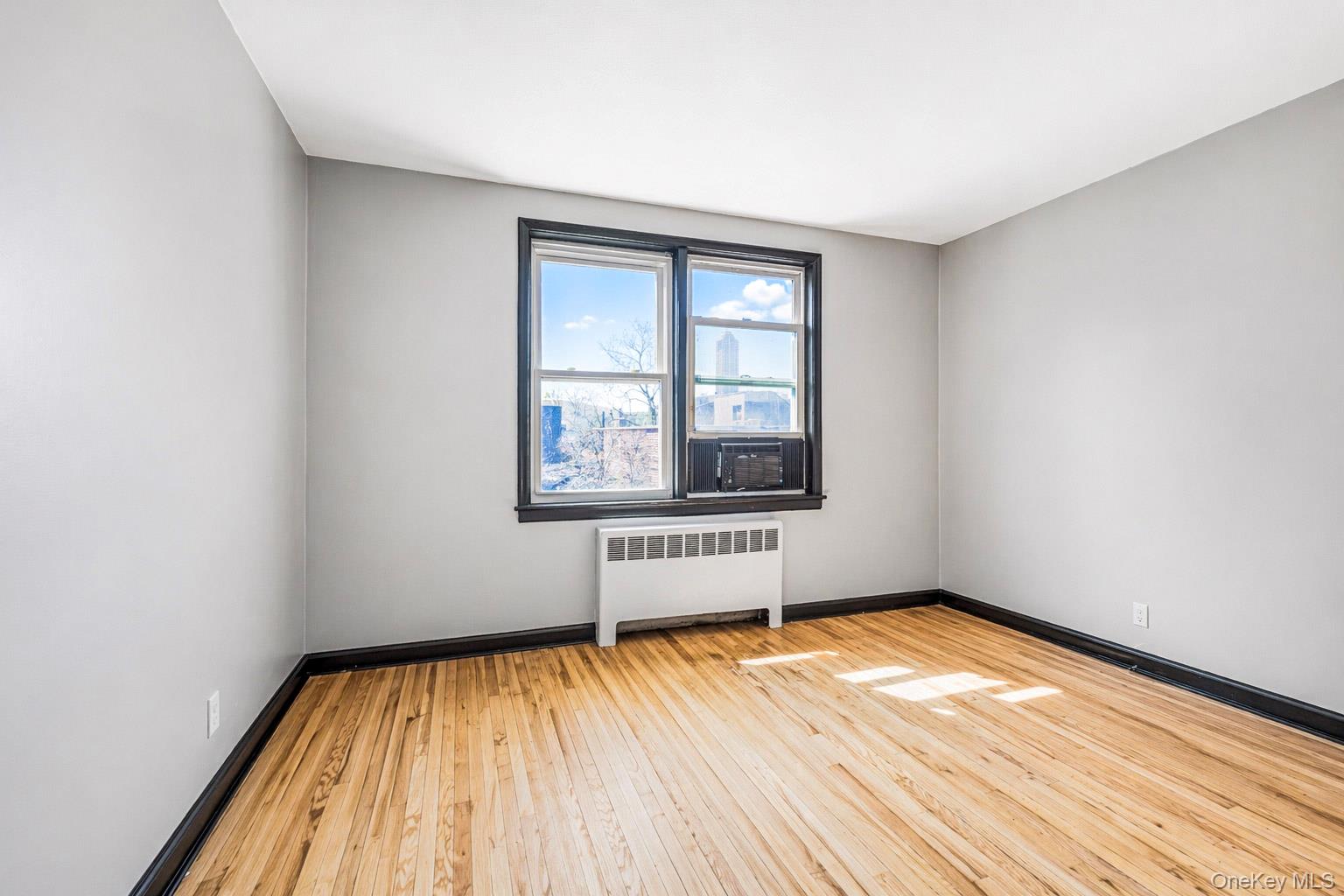 150 Ravine Avenue, Unit 3B Yonkers, NY 10701 - Photo 9 of 9 an empty room with wooden floor and windows