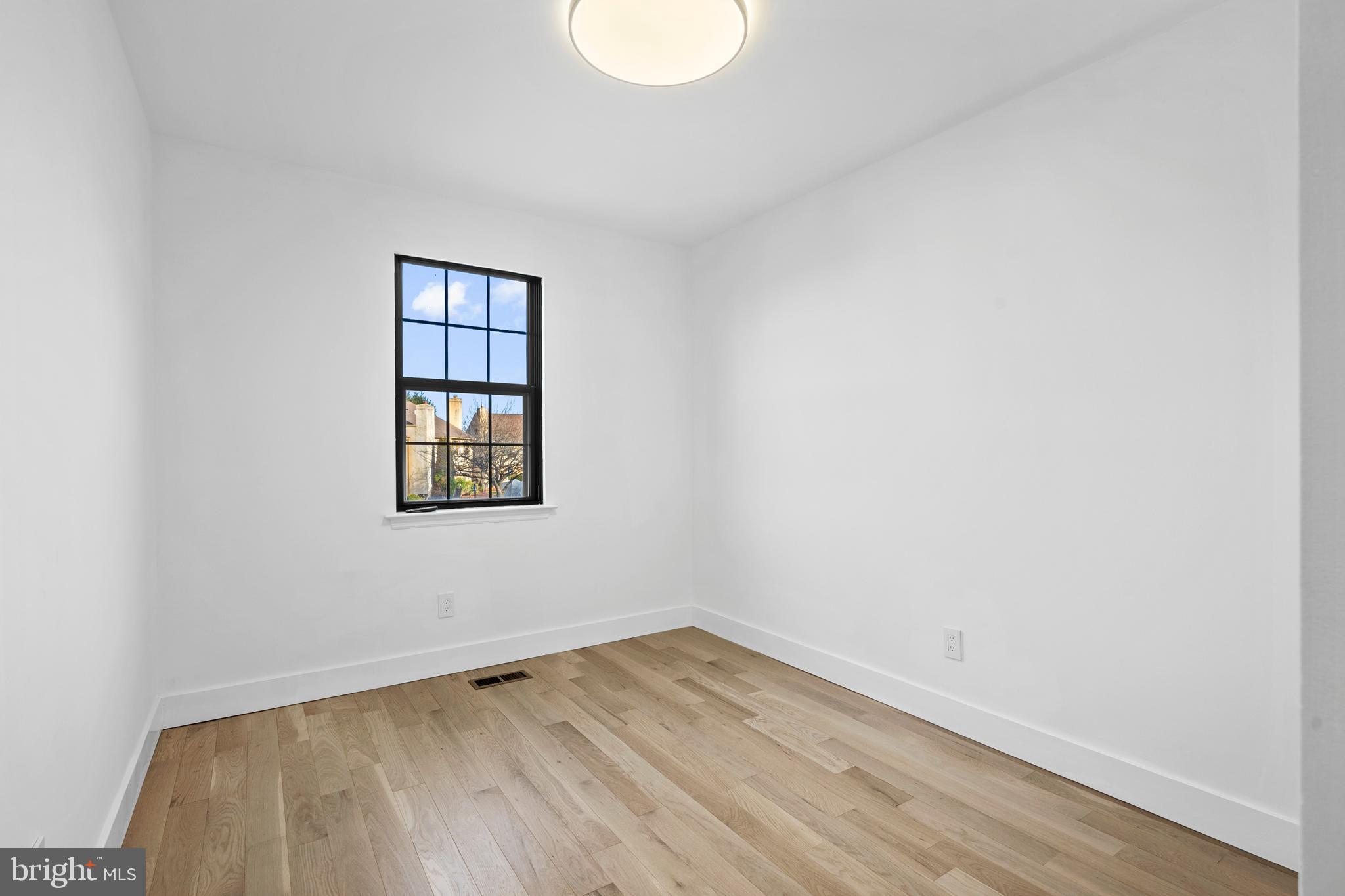 1007 Stoneham Drive, Unit 1007B Newtown Square, PA 19073 - Photo 16 of 31 an empty room with wooden floor and windows
