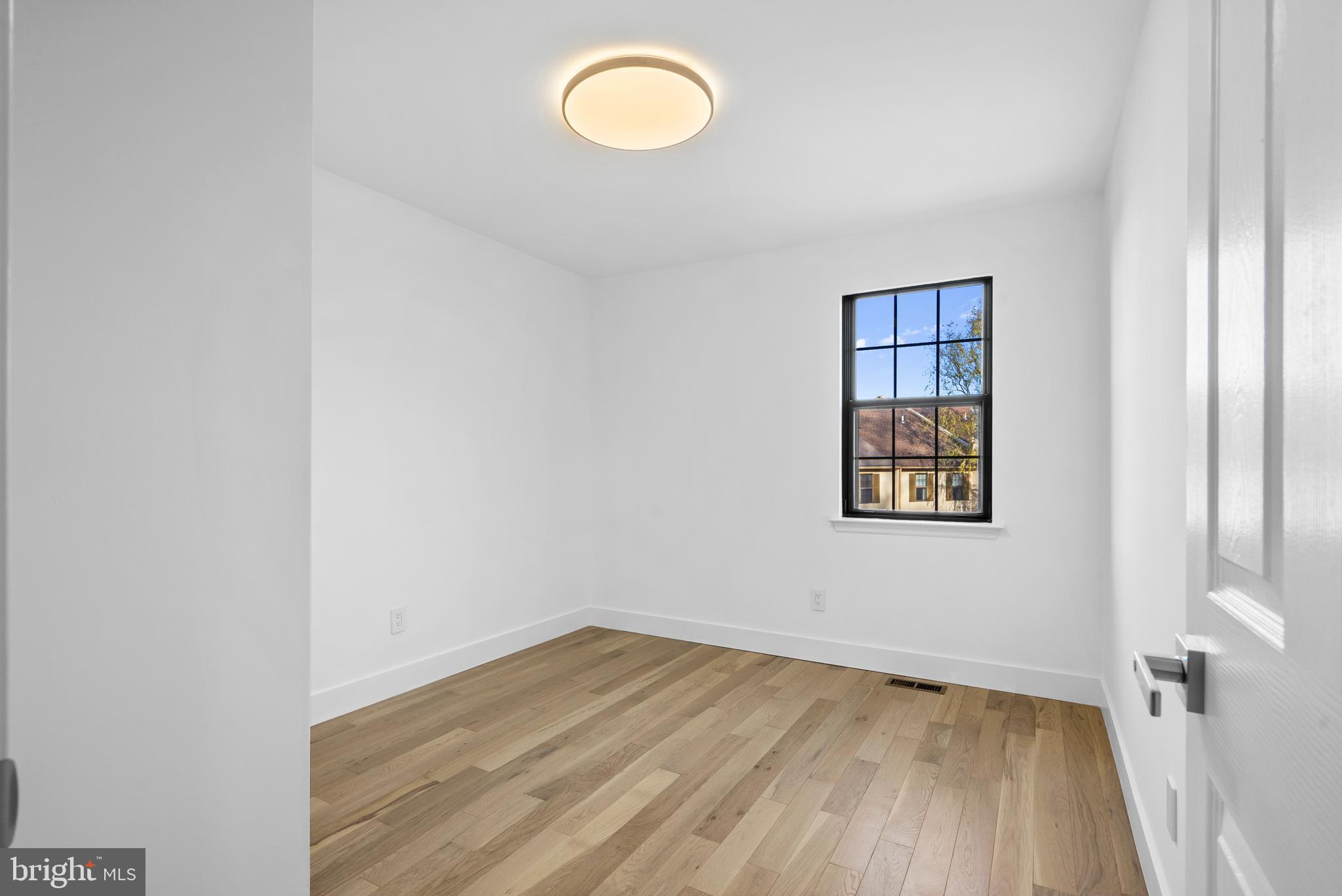 1007 Stoneham Drive, Unit 1007B Newtown Square, PA 19073 - Photo 17 of 31 a view of a room with wooden floor and window