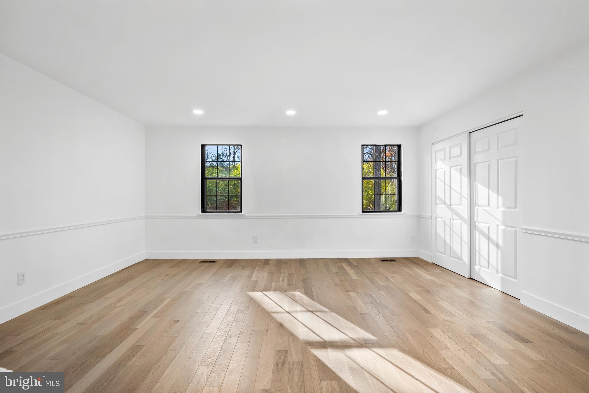 1007 Stoneham Drive, Unit 1007B Newtown Square, PA 19073 - Photo 19 of 31 an empty room with wooden floor and windows