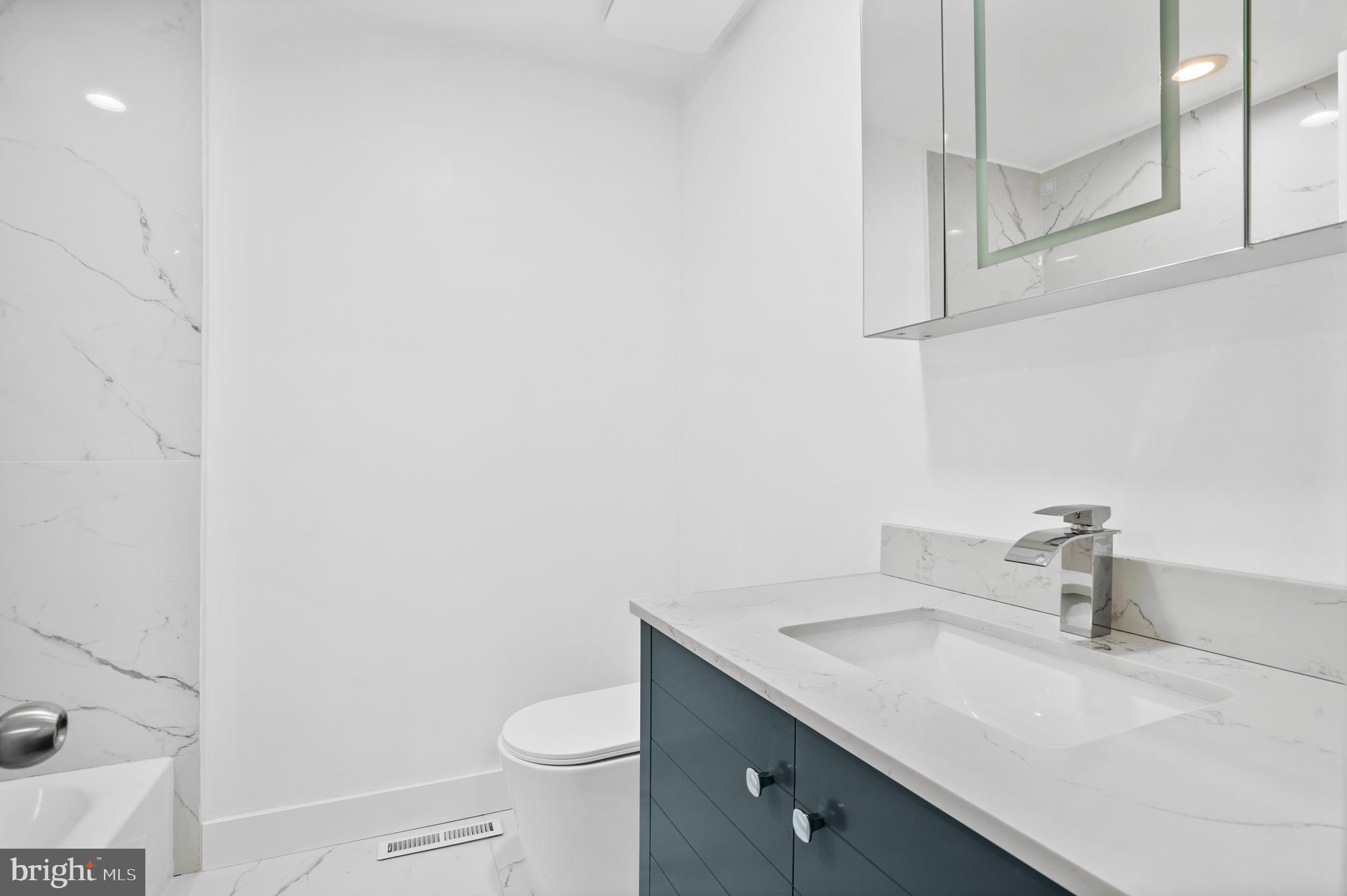 1007 Stoneham Drive, Unit 1007B Newtown Square, PA 19073 - Photo 20 of 31 a bathroom with a granite countertop sink and a toilet
