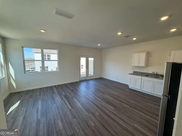 an empty room with wooden floor and windows
