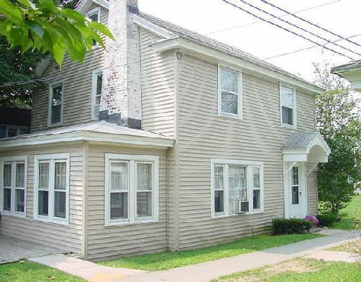 a view of a house with a yard and potted plants
