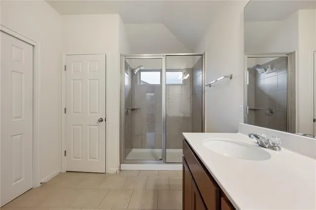 a bathroom with a double vanity sink mirror and shower