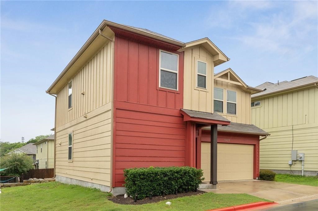 5428 Falling Leaf Lane, Unit 87 Austin, TX 78744 - Photo 2 of 31 a front view of a house with a yard and garage