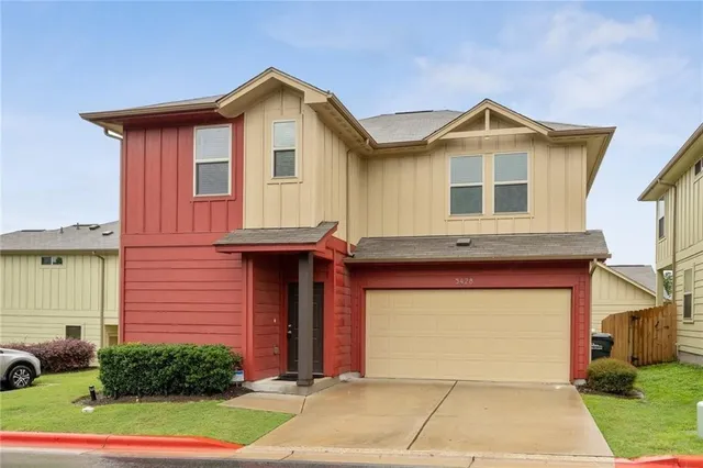 a front view of a house with a yard and garage