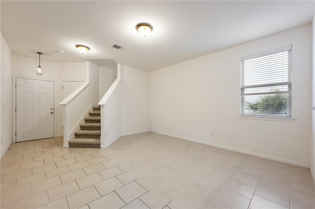 5428 Falling Leaf Lane, Unit 87 Austin, TX 78744 - Photo 6 of 31 an empty room with stairs and windows