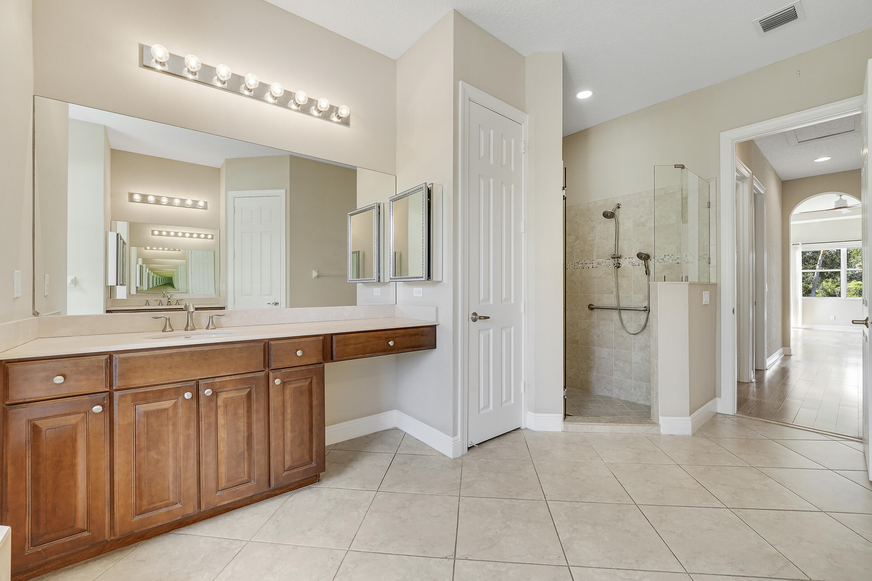 243 Southeast Ethan Terrace Stuart, FL 34997 - Photo 38 of 58 a spacious bathroom with a mirror sink and shower