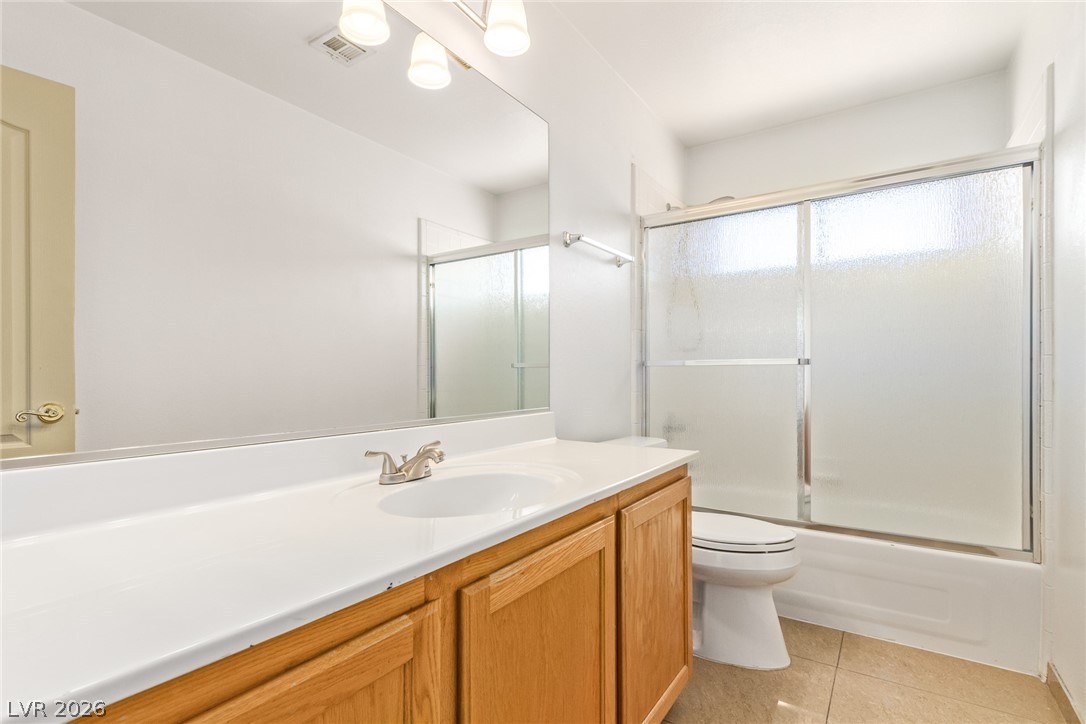 1477 Rancho Ridge Drive Henderson, NV 89012 - Photo 32 of 46 A well-lit bathroom provides a functional vanity, large mirror, and practical shower-tub combination.