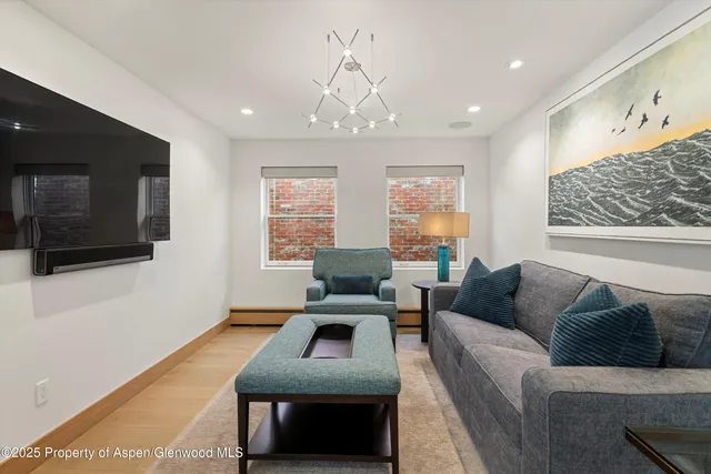 a bedroom with a bed a flat screen tv and a fireplace