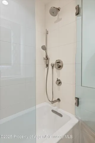 a bathroom with a shower and a glass door